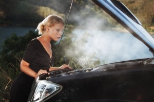 A woman in Los Angeles looking at her overheating car.